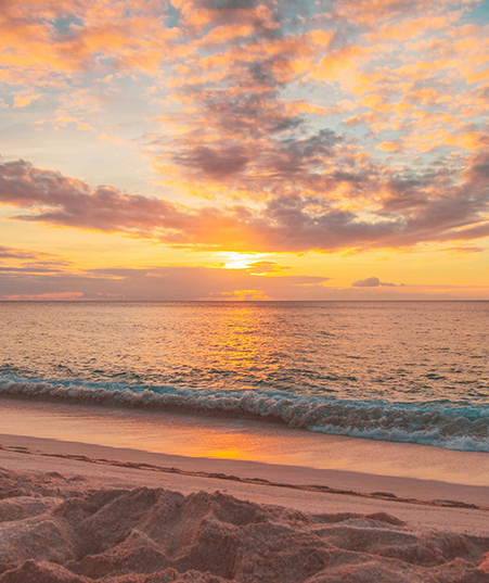 A sunset over the ocean with clouds in the sky.